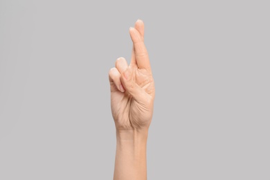 Photo of Woman showing R letter on grey background, closeup. Sign language