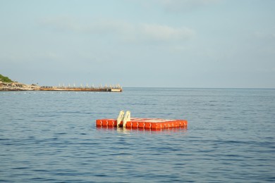Swim platform with ladder floating on sea under blue sky