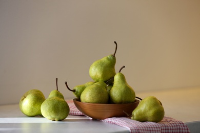 Photo of Bowl with fresh ripe pears on white table