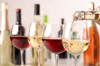 Photo of Pouring white wine from bottle into glass, closeup