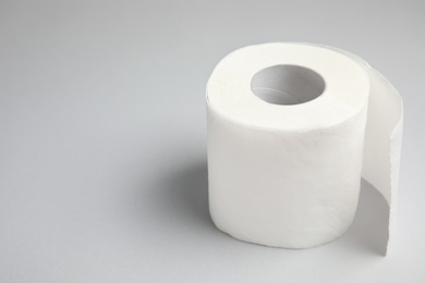 Photo of Toilet paper roll on grey background. Space for text