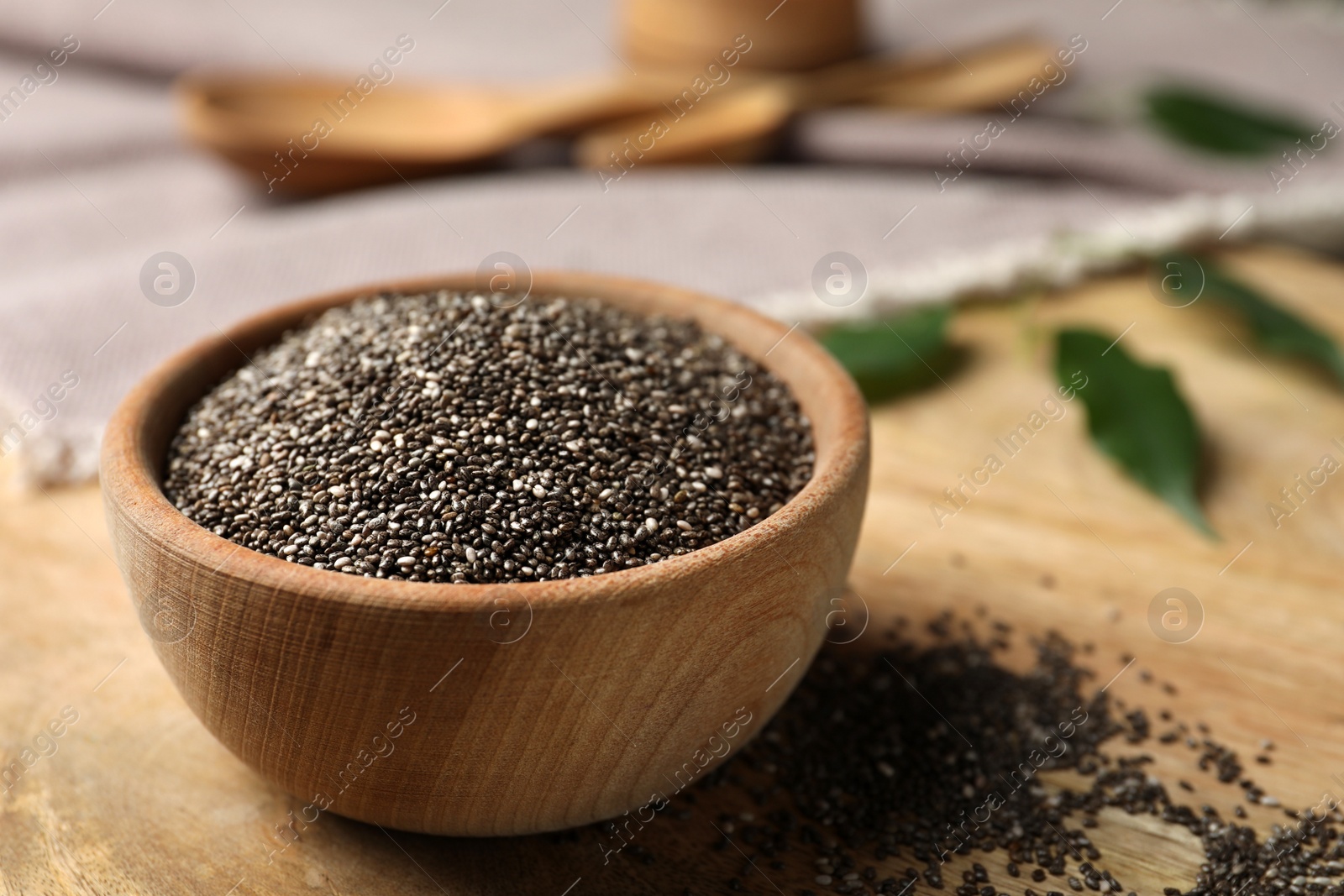 Photo of Chia seeds in bowl on wooden table. Space for text