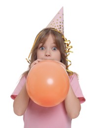 Cute little girl in party hat inflating balloon on white background