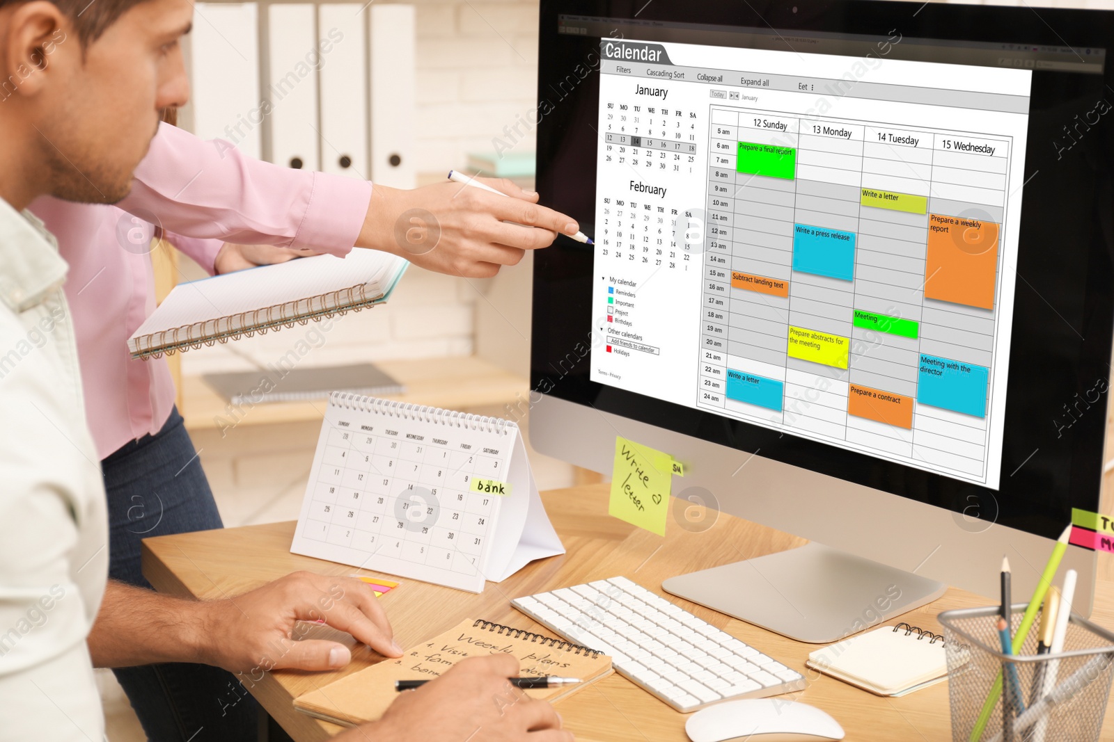 Photo of Colleagues working with calendar app on computer in office, closeup