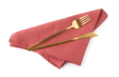 Photo of Red napkin with golden fork and knife isolated on white, top view. Cutlery set