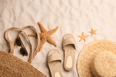 Photo of Different beach accessories on sand, flat lay