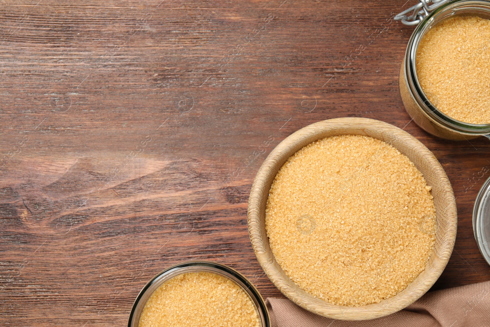 Photo of Different dishes with brown sugar on wooden table, flat lay. Space for text