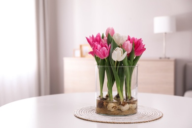 Photo of Bouquet of beautiful tulips with bulbs on table indoors. Space for text