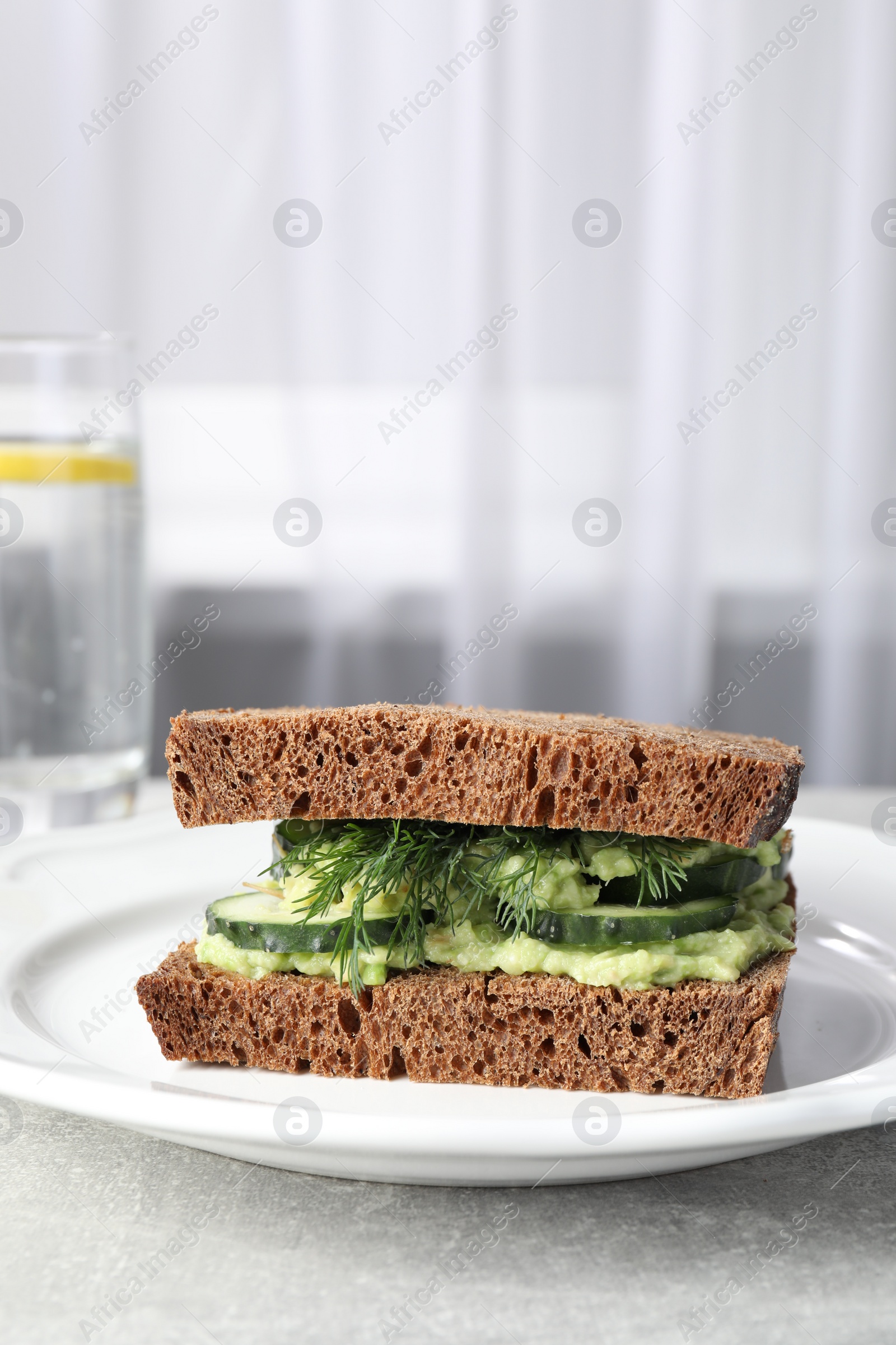 Photo of Tasty sandwich with cucumber, cream cheese and dill on grey table indoors. Space for text