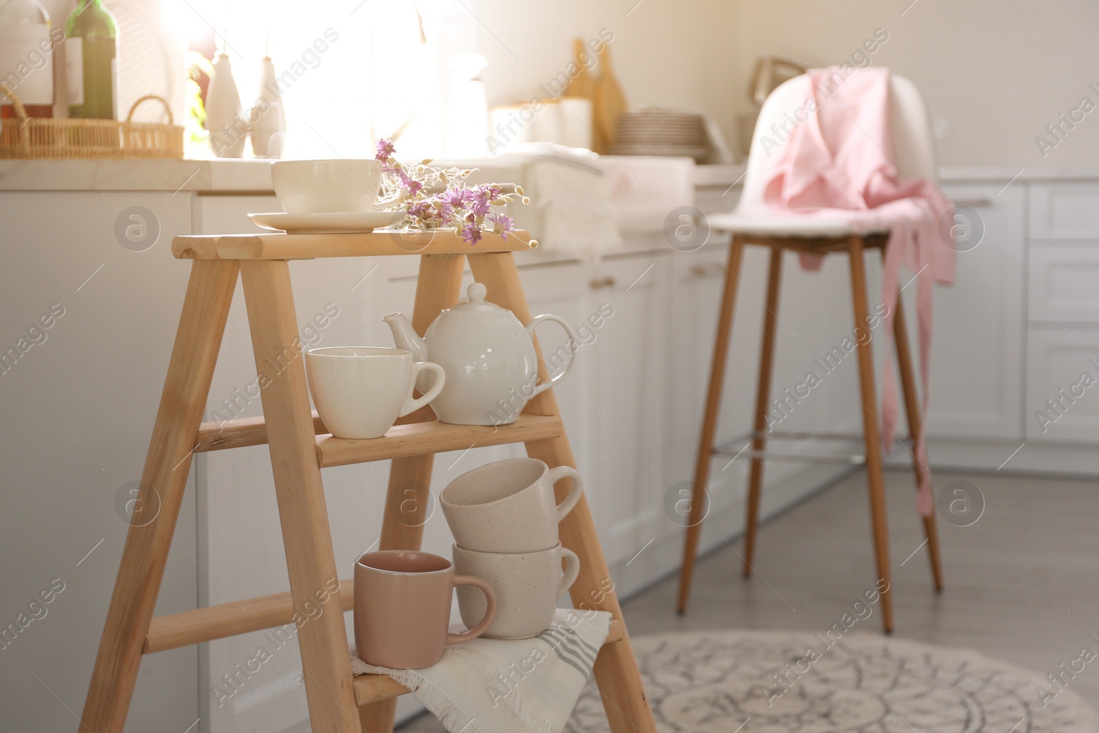 Photo of Decorative ladder with different dishware in kitchen. Idea for interior design