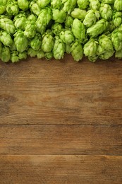 Photo of Fresh green hops on wooden table, top view. Space for text