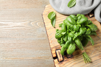 Photo of Fresh basil on wooden table, top view. Space for text