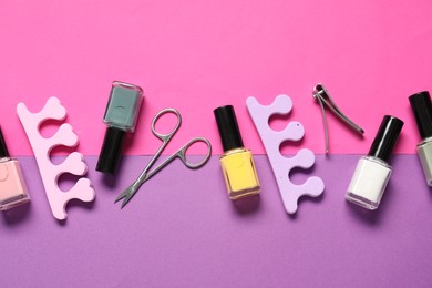 Photo of Nail polishes, clippers, scissors and toe separators on color background, flat lay
