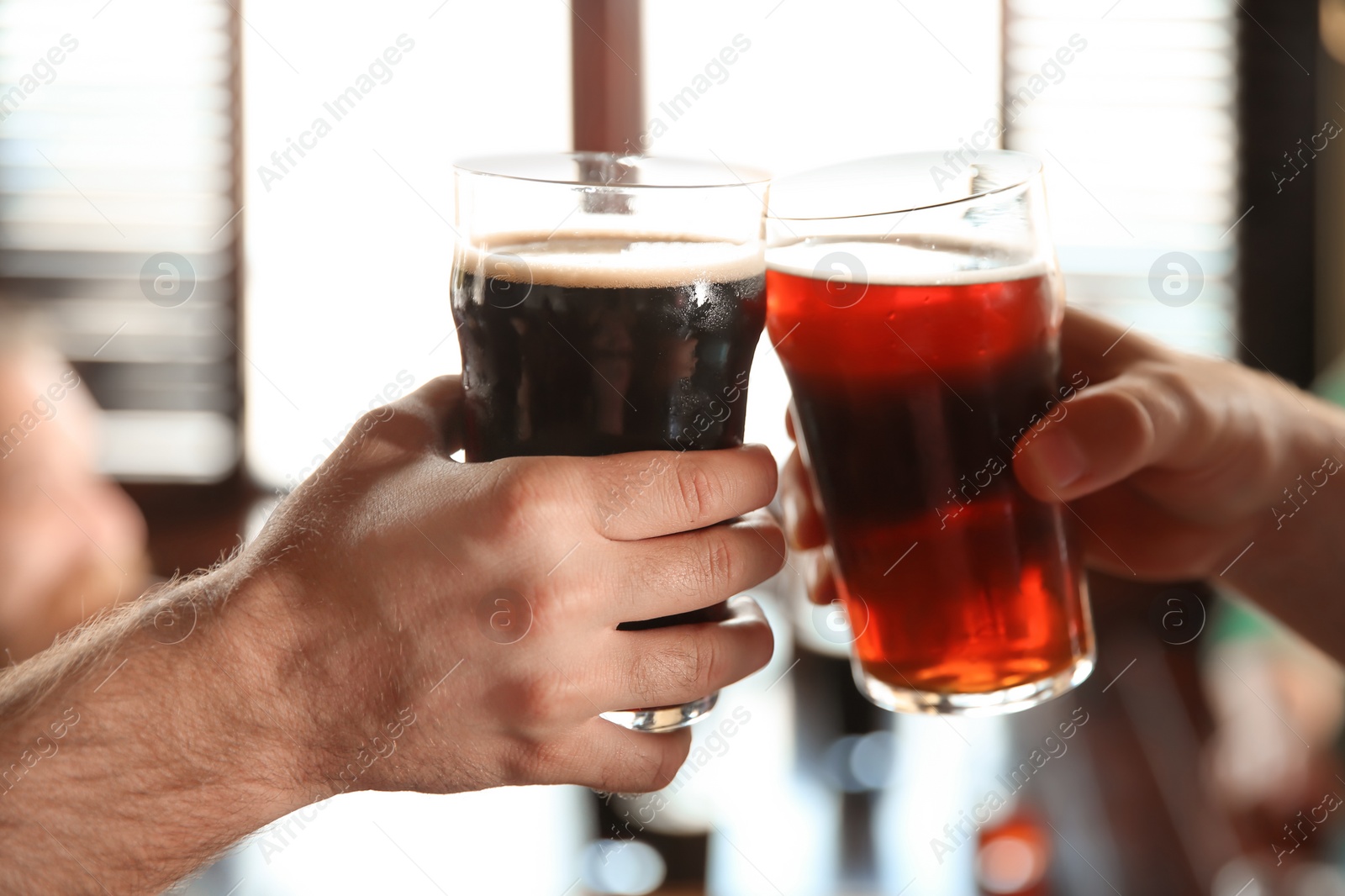 Photo of Friends clinking glasses with beer in pub