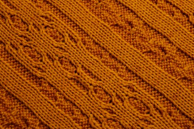 Photo of Beautiful orange knitted fabric as background, top view