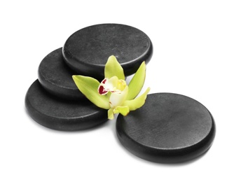 Beautiful orchid flower and spa stones on white background