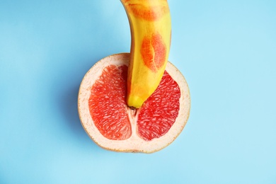 Flat lay composition with fresh banana and grapefruit on blue background. Sex concept