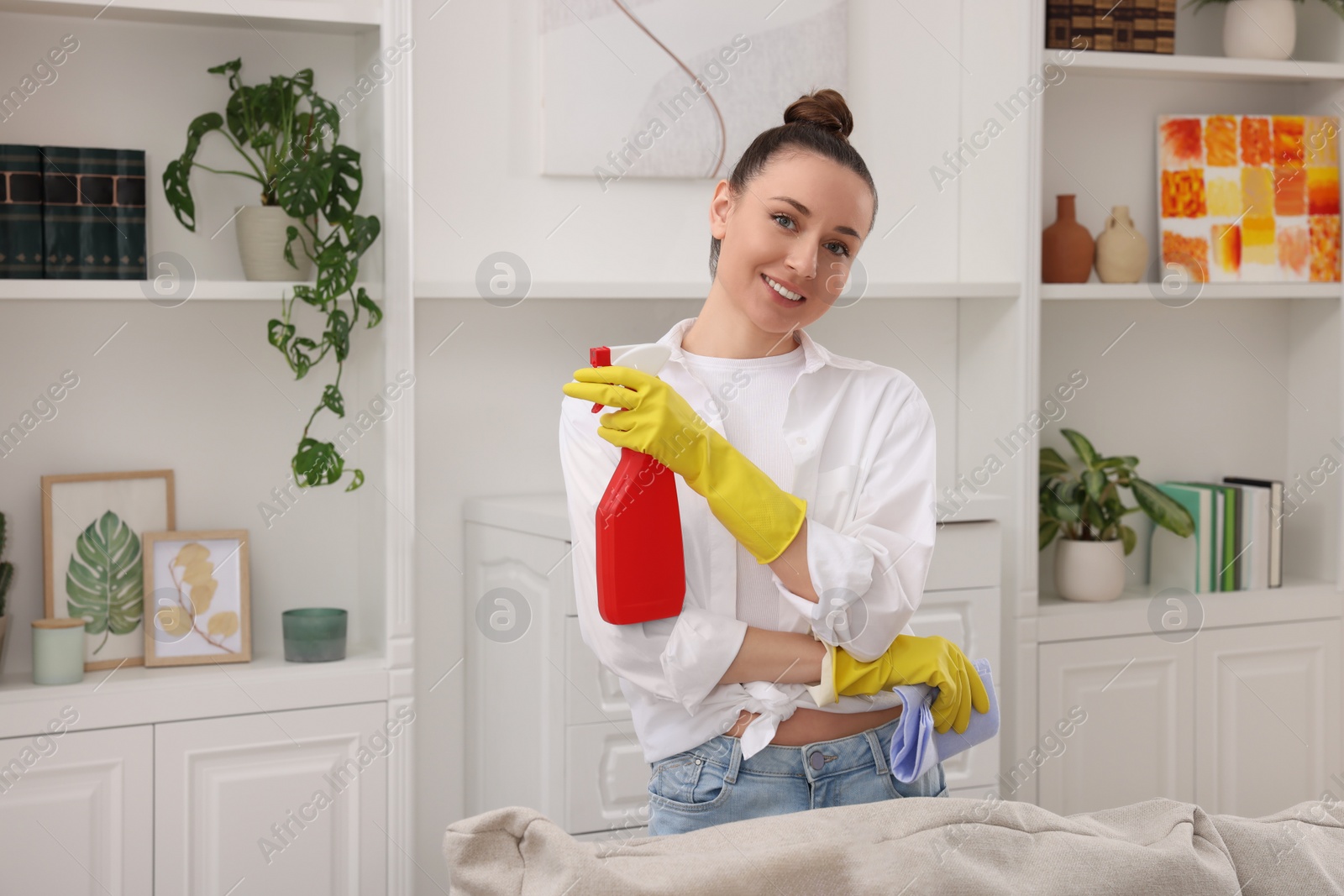 Photo of Spring cleaning. Young woman tidying up room at home