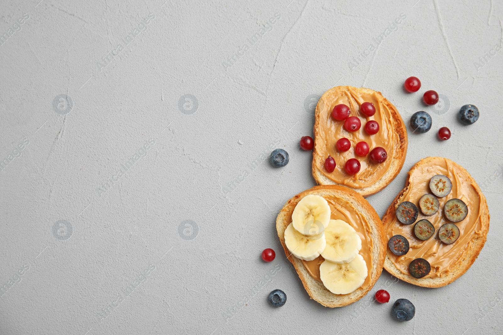 Photo of Slices of bread with different toppings on grey table, flat lay. Space for text