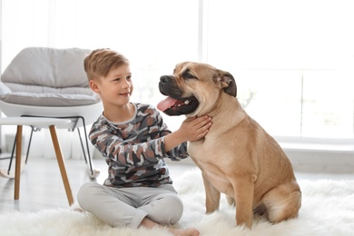 Photo of Cute little child with his dog at home