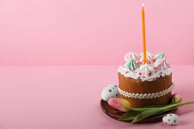 Photo of Traditional Easter cake with meringues, candle, decorated eggs and tulip on pink background. Space for text