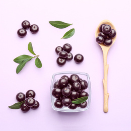 Flat lay composition with acai berries on violet background, flat lay