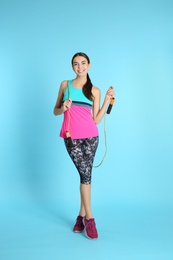 Photo of Full length portrait of young sportive woman with jump rope on color background