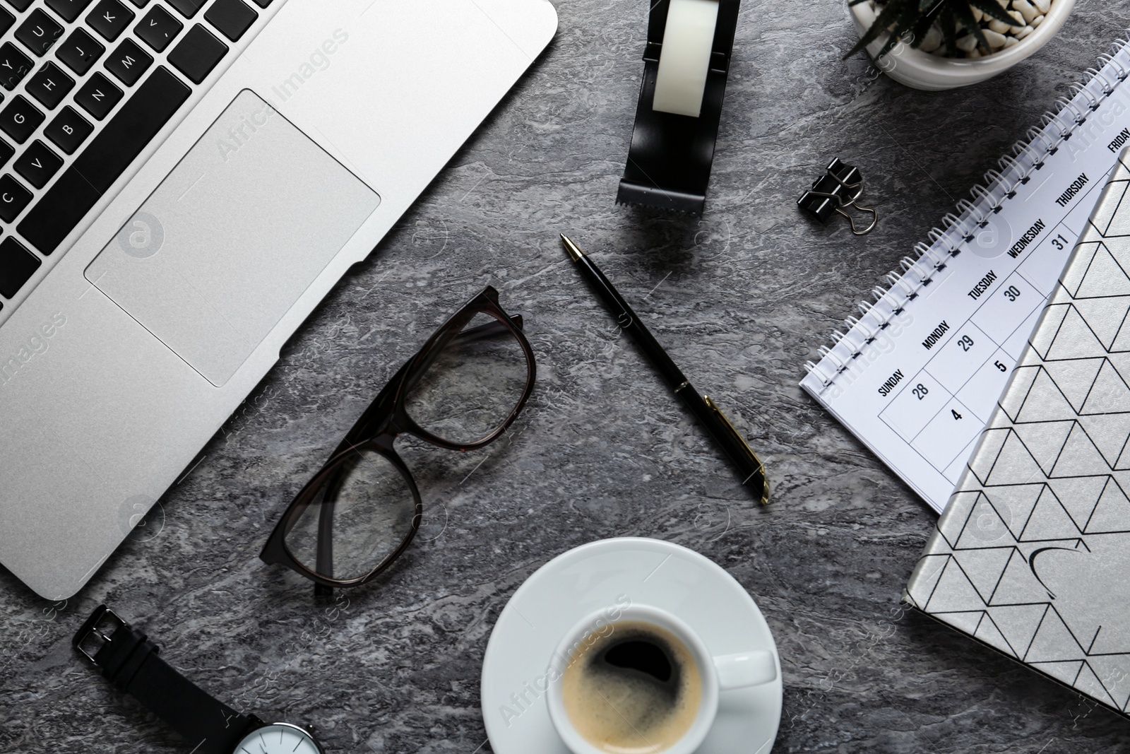 Photo of Flat lay composition with laptop, glasses and stationery on dark grey table