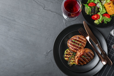 Photo of Delicious beef medallions served on grey table, flat lay. Space for text