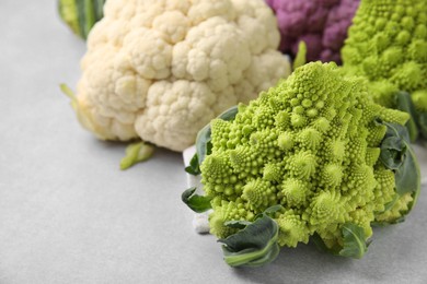 Photo of Different fresh cabbages on white table, closeup. Space for text