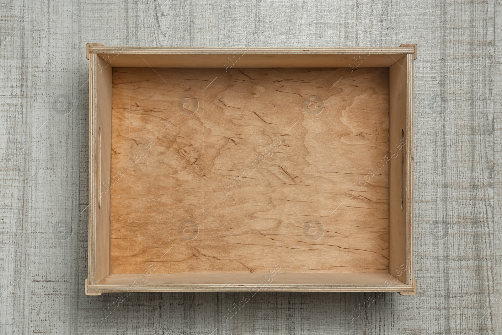 Photo of Empty crate on wooden background, top view