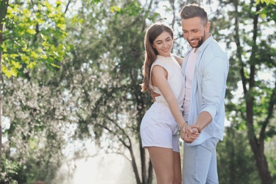 Photo of Lovely young couple dancing together in park on sunny day