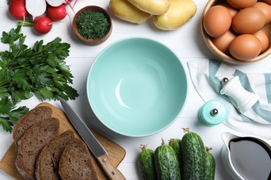 Photo of Flat lay composition of ingredients for okroshka with kvass on white wooden table. Traditional Russian summer soup