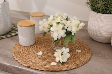 Photo of Beautiful jasmine flowers on wooden table indoors