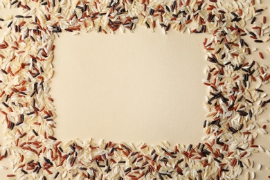 Frame made with mixed brown and other types of rice on color background, top view. Space for text