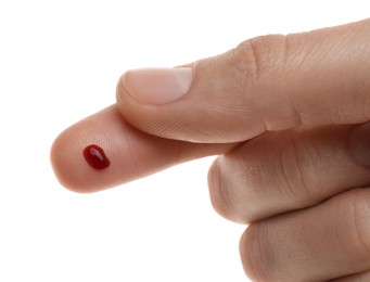 Woman with pricked finger and blood drop on white background, closeup