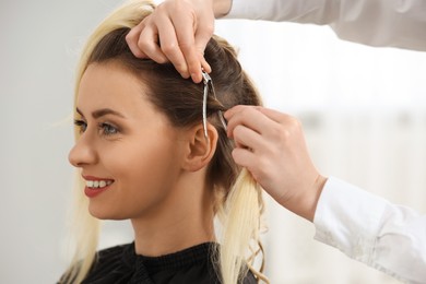 Hair styling. Professional hairdresser working with smiling client indoors, closeup