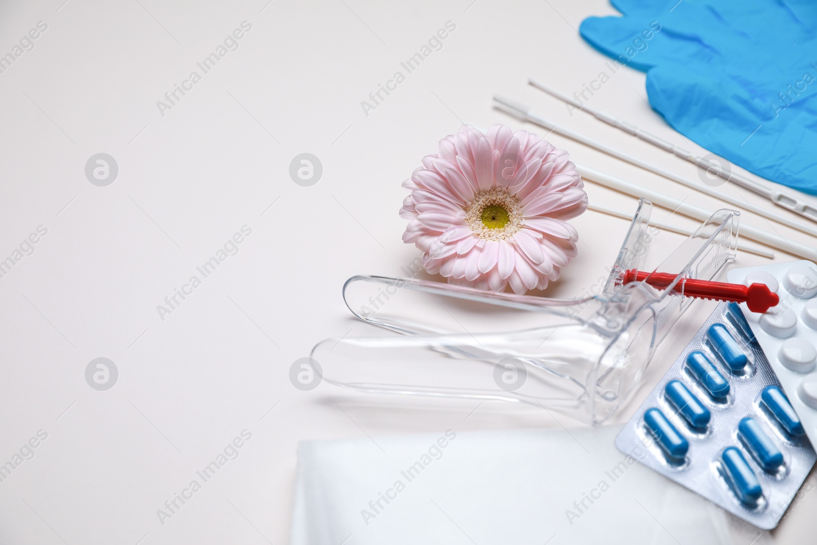 Photo of Gynecological tools, pills and gerbera flower on beige background. Space for text