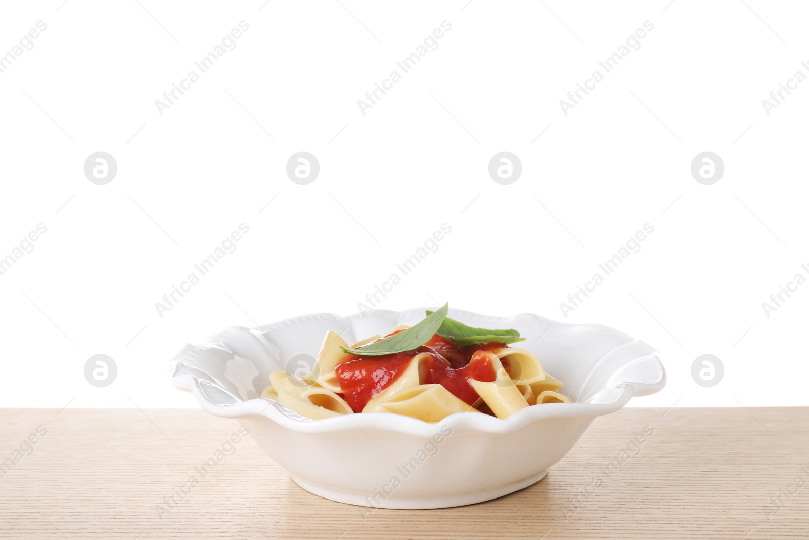 Photo of Delicious maltagliati pasta with tomato sauce on wooden table