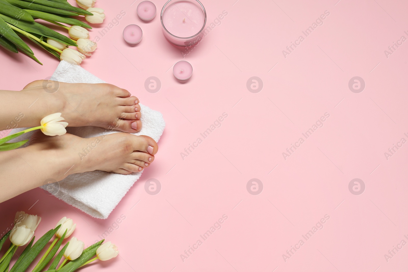 Photo of Closeup of woman with neat toenails after pedicure procedure on pink background, top view. Space for text