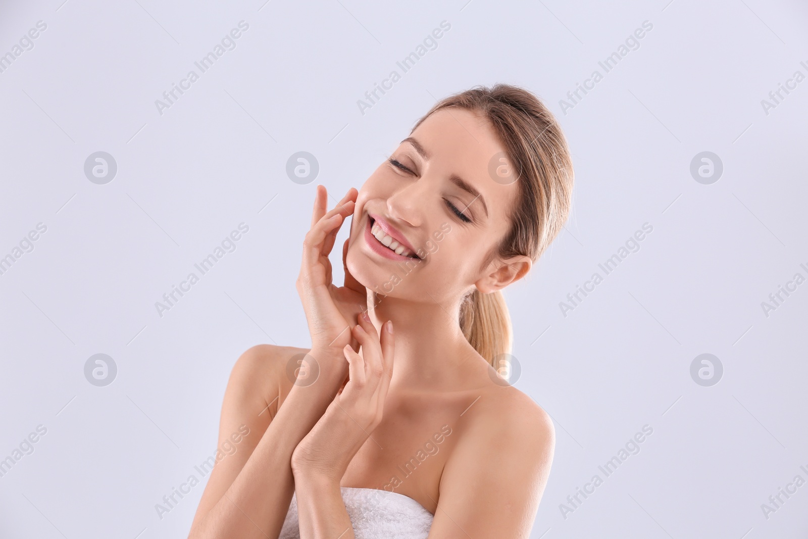 Photo of Young woman with silky skin on light background