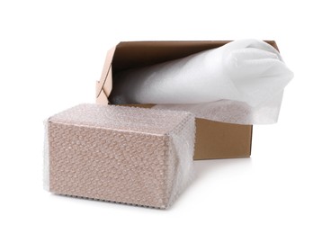 Cardboard boxes with bubble wrap and packaging foam on white background