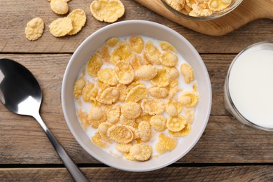 Photo of Tasty cornflakes with milk served on wooden table, flat lay