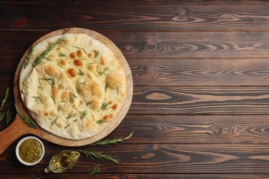 Photo of Flat lay composition with focaccia bread on wooden table. Space for text