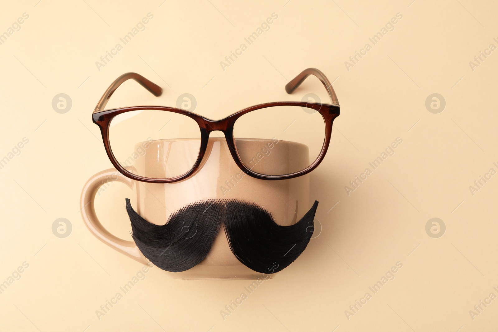 Photo of Artificial moustache, cup and glasses on beige background, top view. Space for text