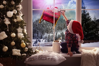 Image of Cute little child on window sill at home waiting for Santa Claus. Christmas celebration