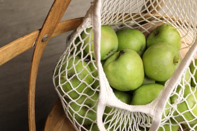 Photo of Fresh green apples in net bag, closeup