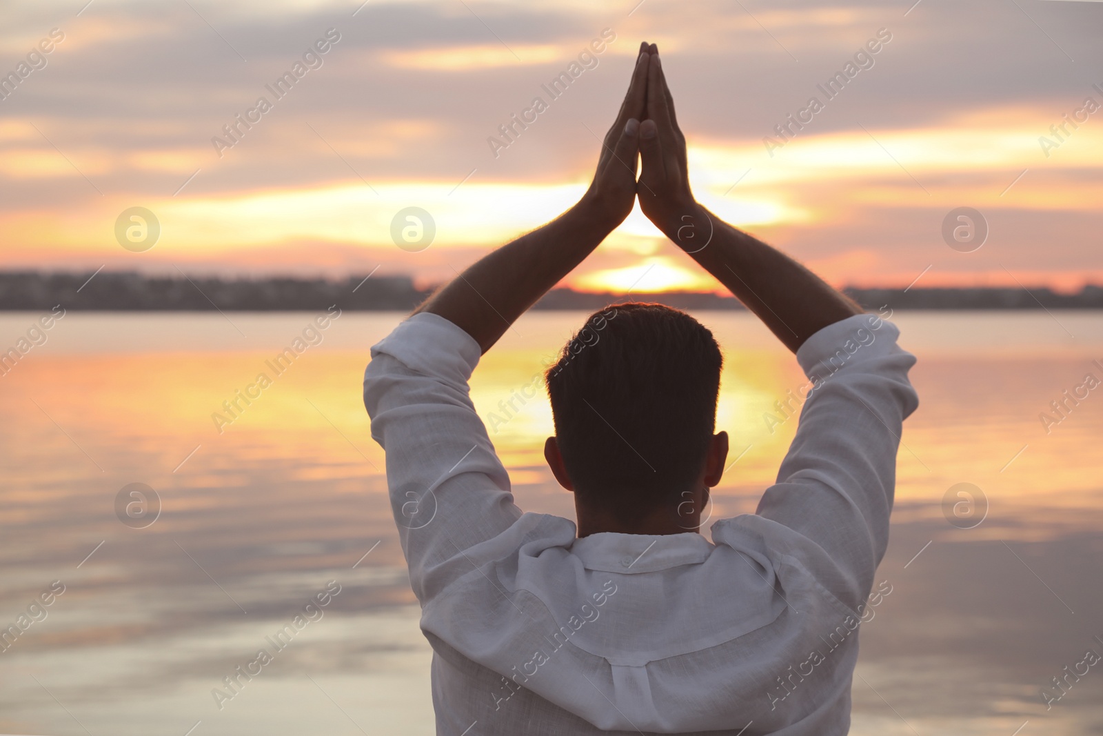 Photo of Man near river at sunset, back view. Nature healing power