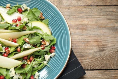 Photo of Fresh salad with pear on wooden table, top view. Space for text