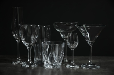 Photo of Set of bar glassware on table against dark background